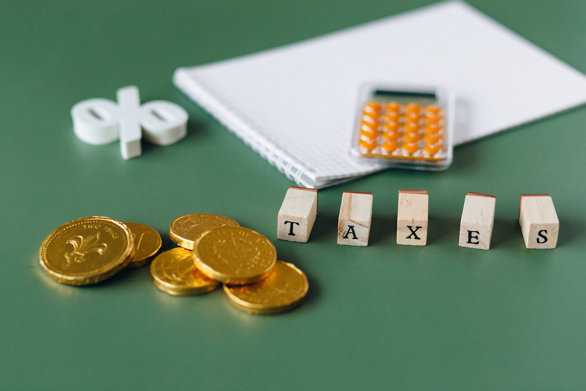 Gold coins and wooden blocks with the word taxes